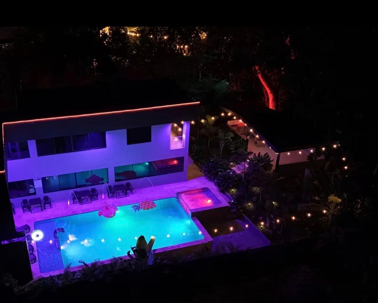 Villa Renacer iluminada de noche con luces de colores