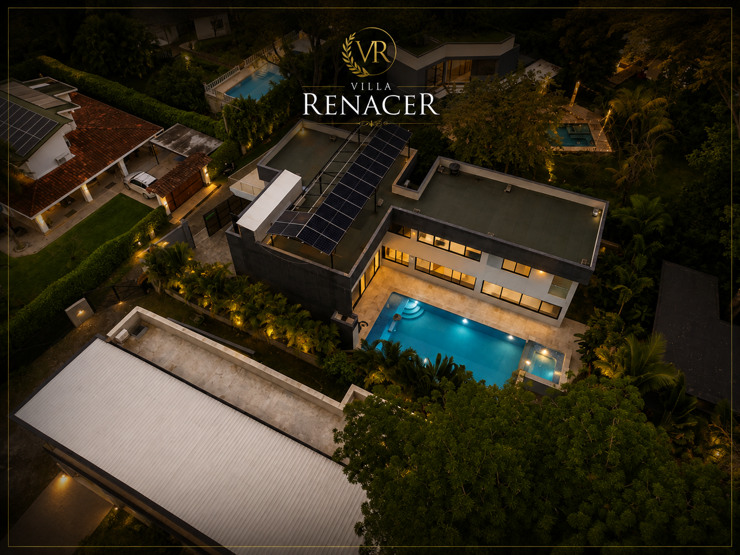 Vista aérea nocturna de Villa Renacer con piscina iluminada y jardines